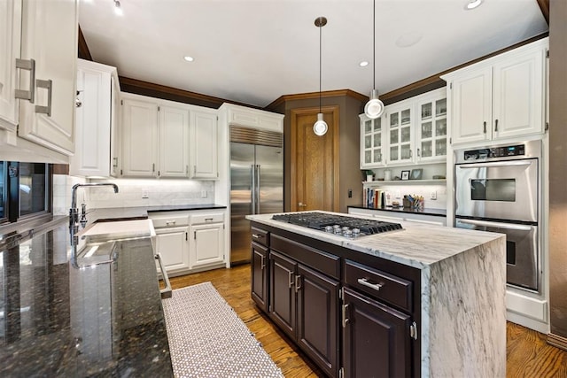 kitchen featuring decorative backsplash, stainless steel appliances, white cabinetry, and a sink