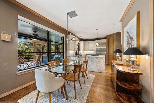 dining area featuring crown molding, a ceiling fan, baseboards, and light wood-type flooring