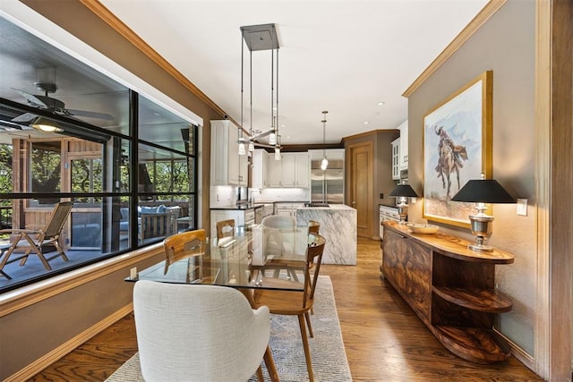 dining area featuring baseboards, a ceiling fan, light wood finished floors, and ornamental molding