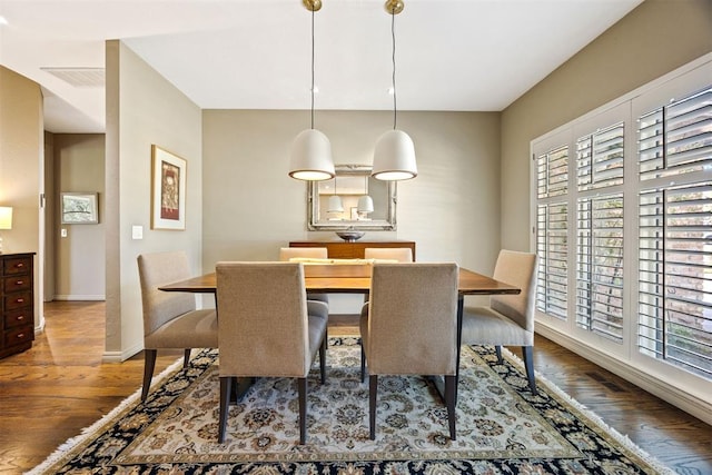 dining space with baseboards, visible vents, a wealth of natural light, and wood finished floors