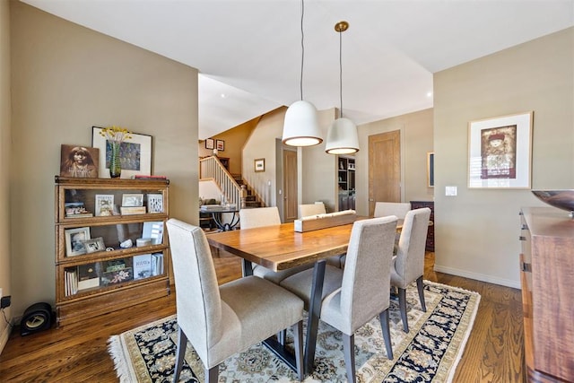 dining space featuring baseboards, stairs, and wood finished floors