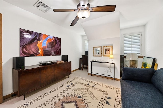 interior space with baseboards, a ceiling fan, and visible vents
