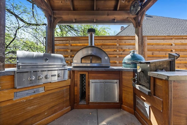 view of patio featuring exterior kitchen, grilling area, and fence