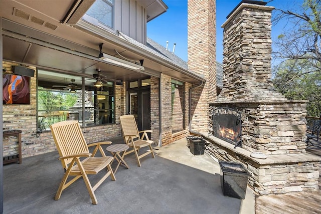 view of patio with an outdoor stone fireplace, a ceiling fan, and visible vents