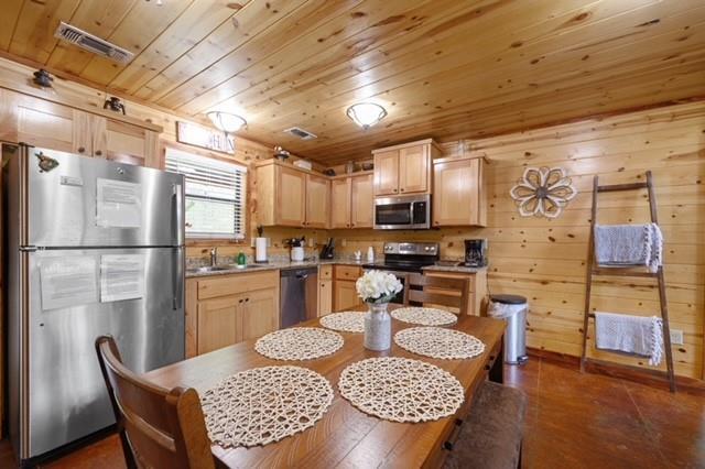 kitchen with stainless steel appliances, light countertops, visible vents, light brown cabinets, and wooden ceiling