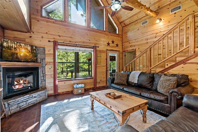 living area with wooden ceiling, visible vents, wood walls, and stairway