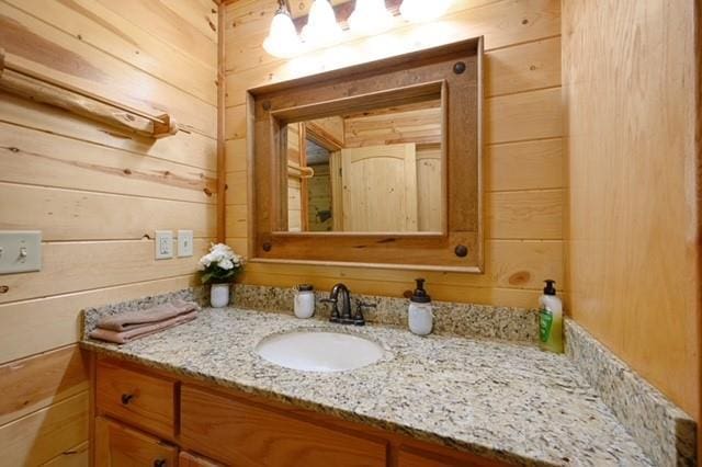 bathroom with wood walls and vanity