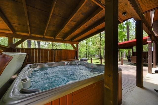 view of patio featuring a hot tub and fence