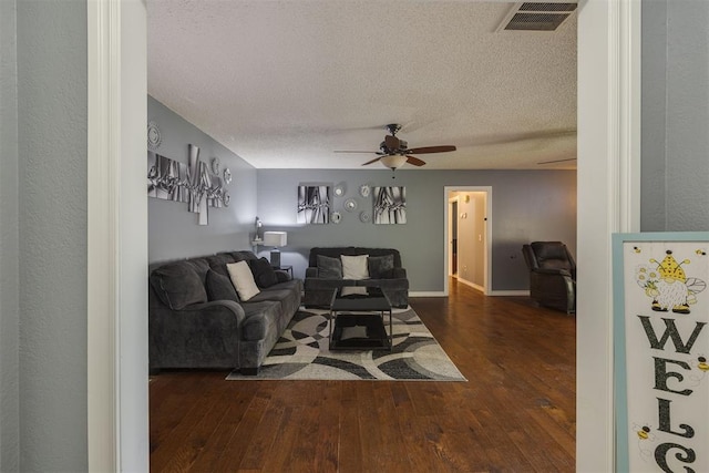 living room featuring a ceiling fan, a textured ceiling, hardwood / wood-style floors, and visible vents