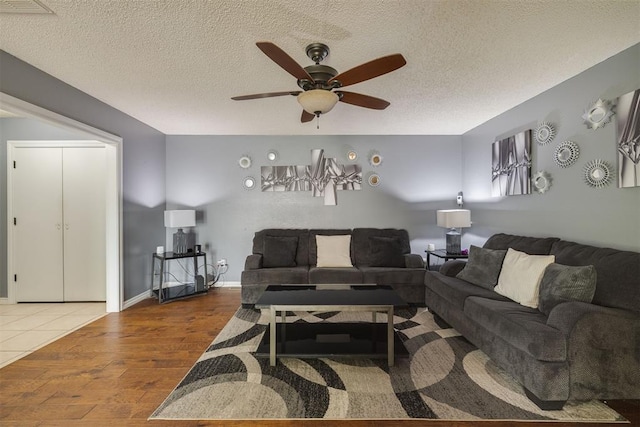 living room with ceiling fan, a textured ceiling, and wood finished floors