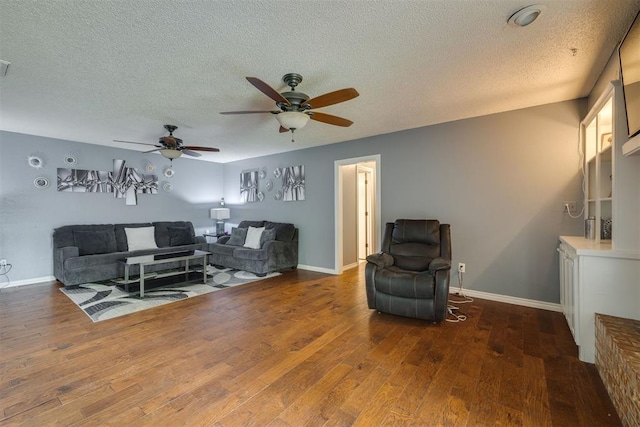 living area featuring a ceiling fan, baseboards, a textured ceiling, and wood finished floors