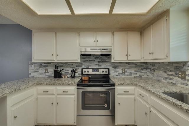 kitchen featuring light stone countertops, under cabinet range hood, stainless steel electric stove, decorative backsplash, and white cabinets