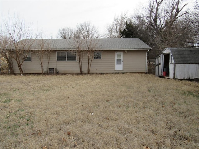 111 W Hillcrest Ln, Hobart, OK 73651 - rear view of property featuring a shingled roof, an outdoor structure, a yard, cooling unit, and a storage unit