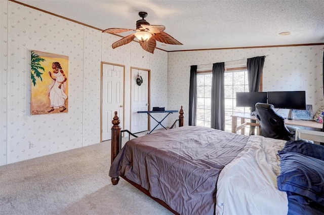 bedroom with a textured ceiling, ceiling fan, carpet flooring, ornamental molding, and wallpapered walls