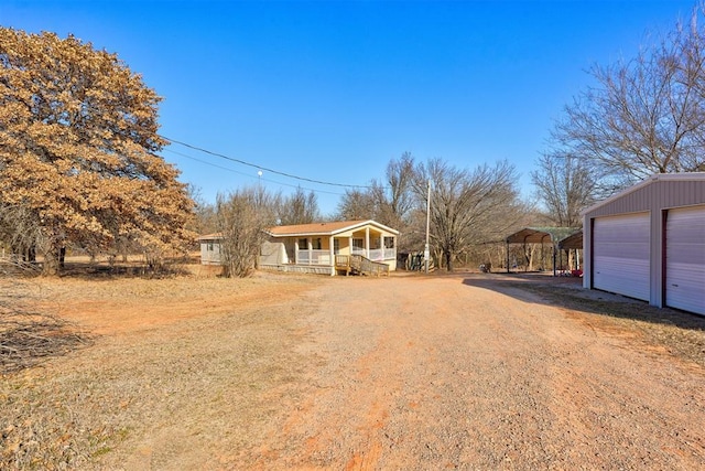 view of front of house featuring covered porch, an outdoor structure, and a garage