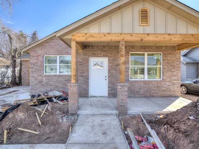 view of front facade featuring board and batten siding and brick siding