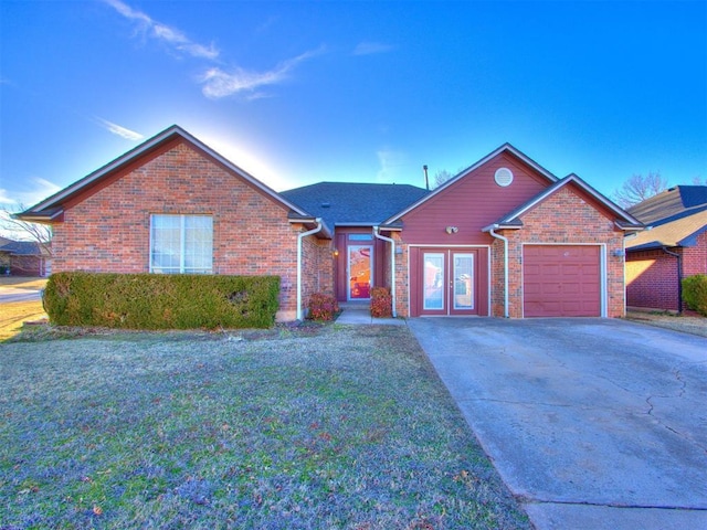 ranch-style home with a garage, french doors, concrete driveway, and brick siding