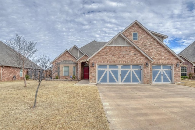 craftsman-style home featuring driveway, brick siding, an attached garage, and a front yard