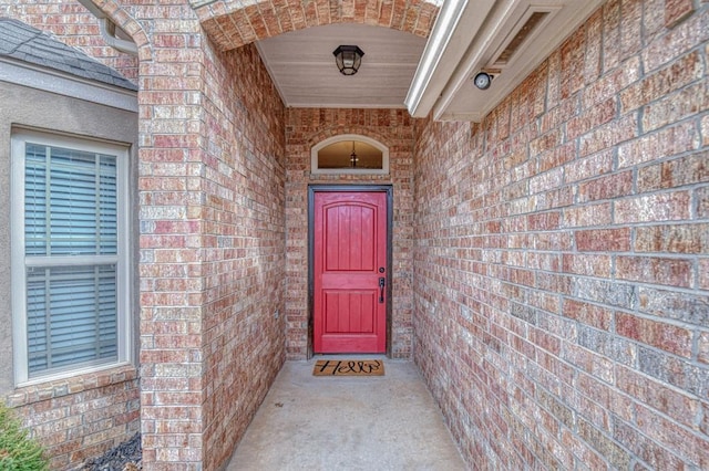 entrance to property featuring brick siding