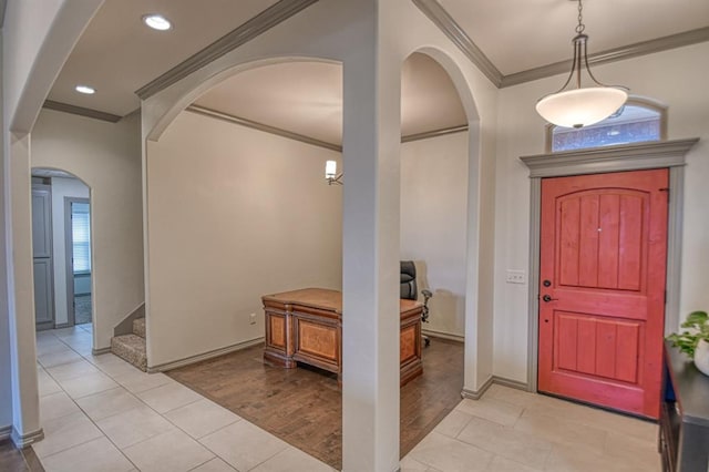 foyer entrance with arched walkways, stairway, crown molding, light wood-type flooring, and recessed lighting