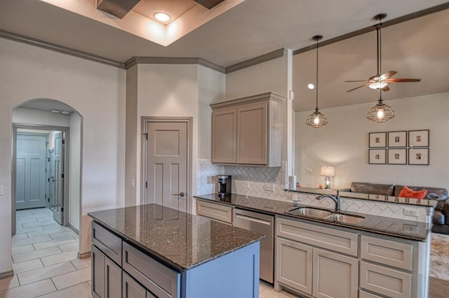 kitchen featuring arched walkways, decorative backsplash, dishwasher, open floor plan, and a sink