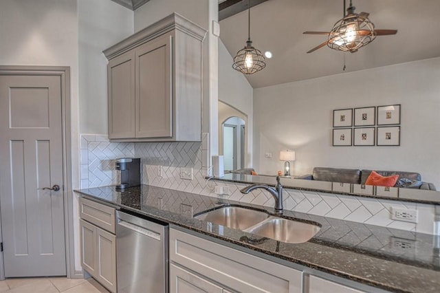 kitchen featuring dark stone counters, open floor plan, a sink, and stainless steel dishwasher