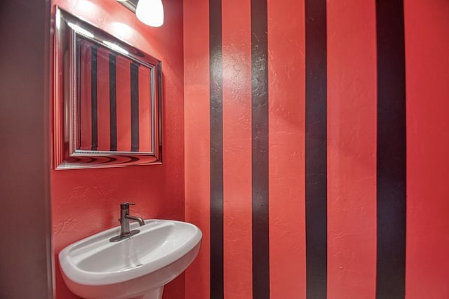 bathroom with a textured wall and a sink