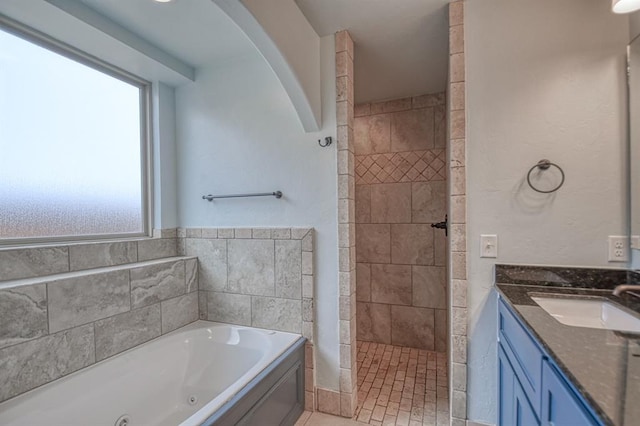 full bath with tile patterned flooring, tiled shower, a jetted tub, and vanity