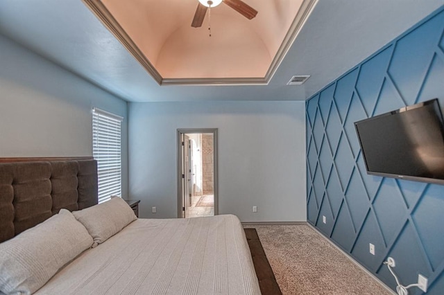 bedroom with a tray ceiling, visible vents, ceiling fan, and carpet flooring