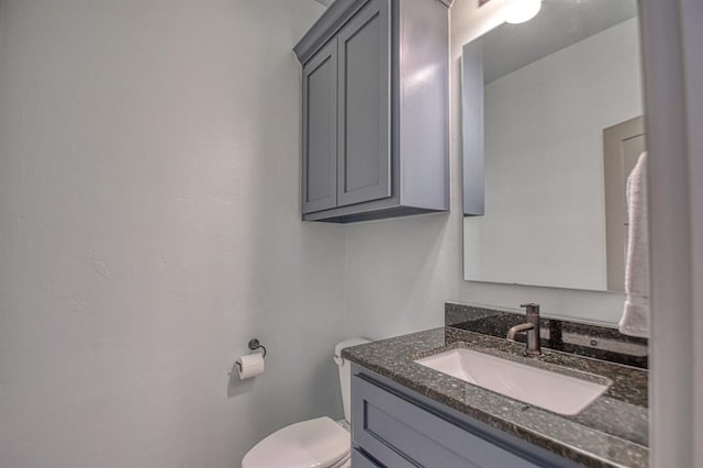 half bathroom with vanity and toilet