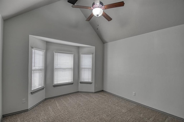 carpeted spare room with high vaulted ceiling, ceiling fan, and baseboards