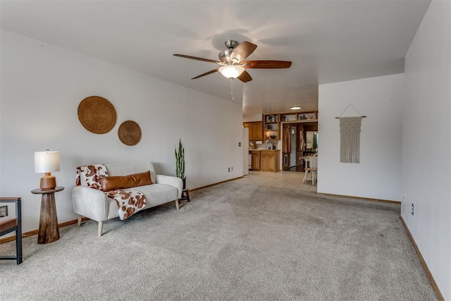 interior space featuring light carpet, baseboards, and a ceiling fan