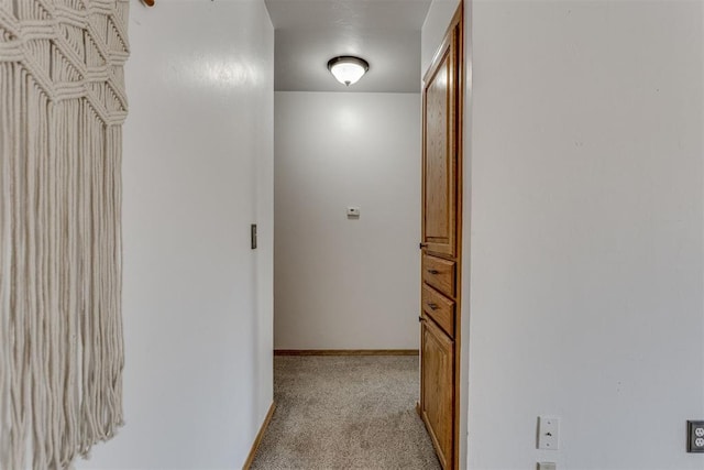 corridor featuring light carpet and baseboards