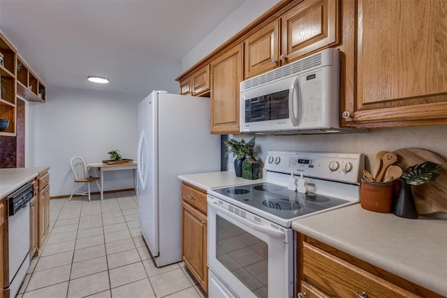 kitchen with light tile patterned floors, light countertops, white appliances, and brown cabinets