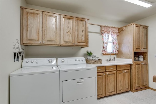 clothes washing area featuring cabinet space, a sink, and washing machine and clothes dryer