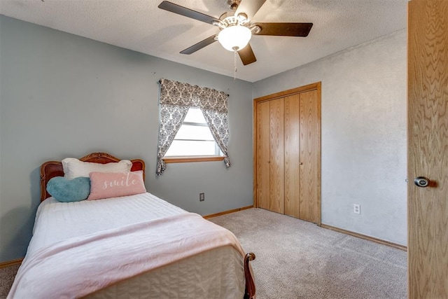 bedroom featuring carpet, a closet, a textured ceiling, and baseboards