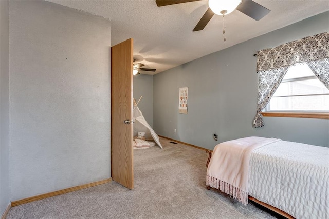 carpeted bedroom with a ceiling fan, a textured ceiling, and baseboards