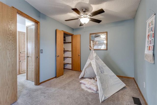 rec room featuring a textured ceiling, carpet flooring, visible vents, and baseboards