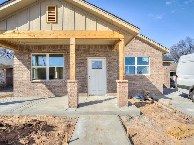 entrance to property with brick siding and board and batten siding