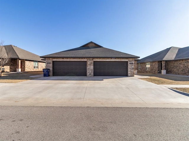 view of front of property with a shingled roof, concrete driveway, brick siding, and an attached garage