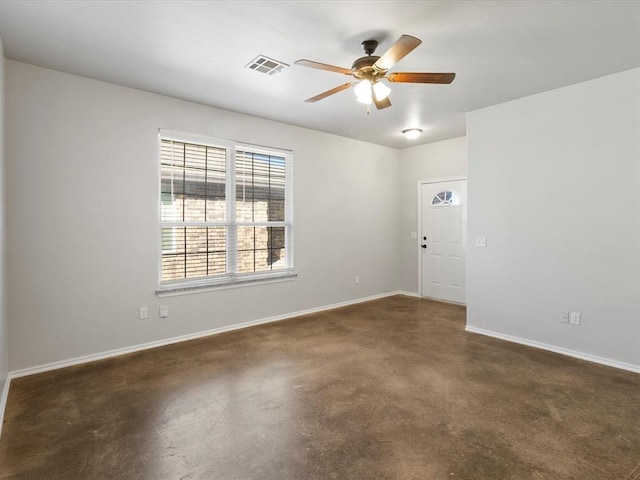 unfurnished room featuring finished concrete floors, visible vents, baseboards, and a ceiling fan