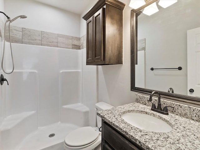 bathroom featuring toilet, walk in shower, and vanity