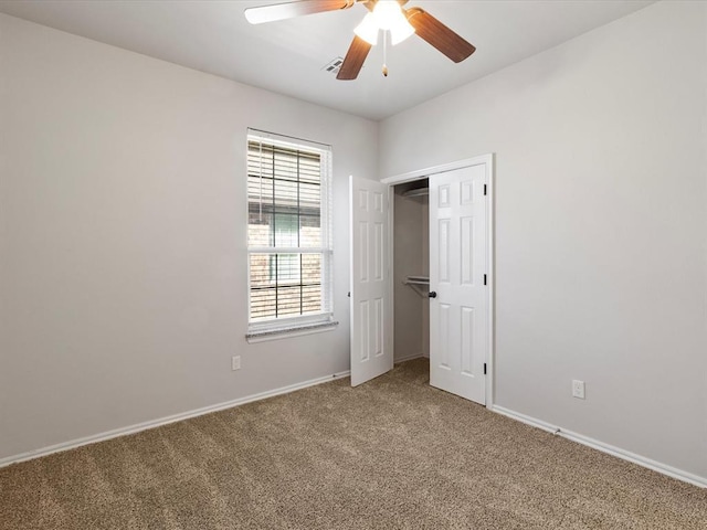 unfurnished bedroom featuring a ceiling fan, a closet, light carpet, and baseboards