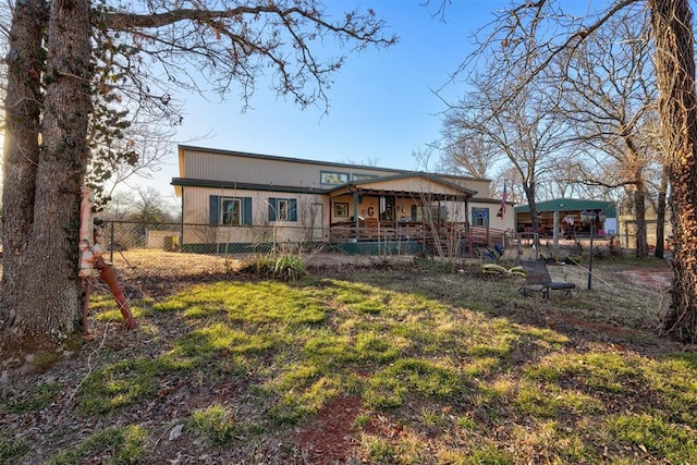 rear view of house featuring fence