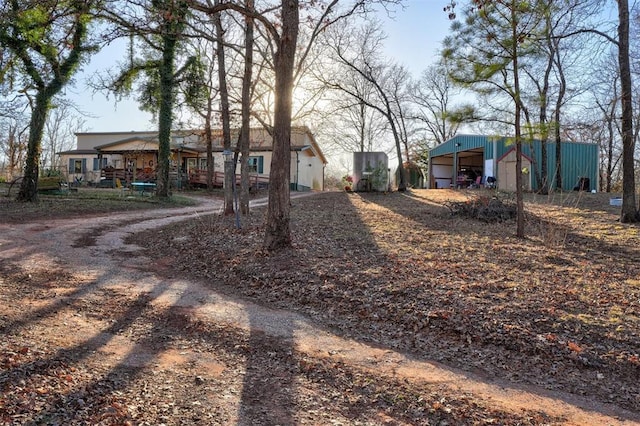 view of yard with driveway, a pole building, and an outdoor structure