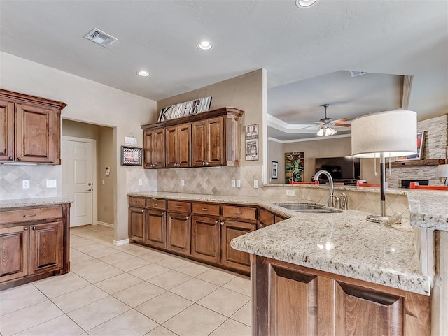 kitchen featuring light tile patterned floors, a sink, visible vents, and decorative backsplash