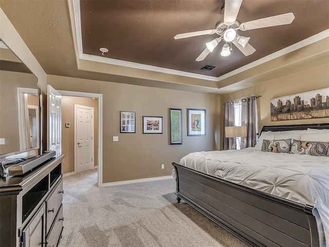 bedroom with baseboards, a tray ceiling, visible vents, and light colored carpet