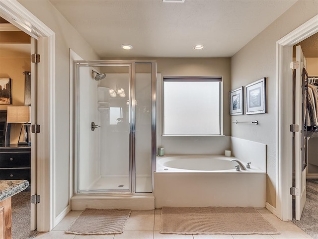 bathroom featuring a garden tub, recessed lighting, a spacious closet, a stall shower, and tile patterned flooring