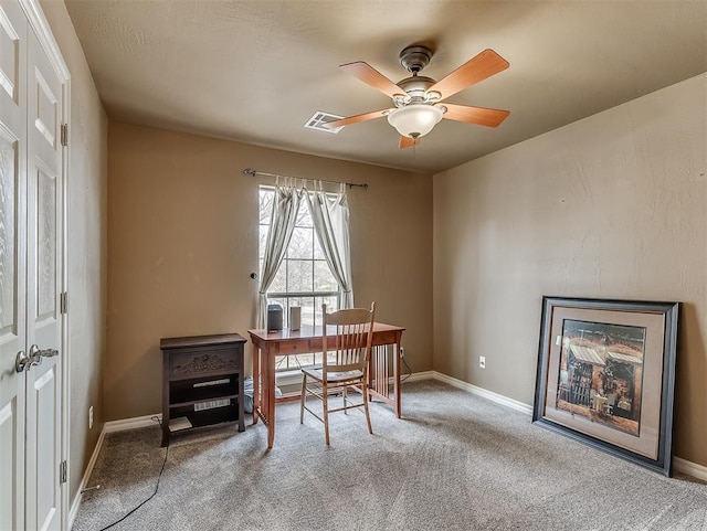 office space featuring baseboards, ceiling fan, visible vents, and carpet flooring