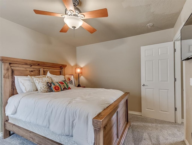 bedroom featuring light colored carpet, ceiling fan, and baseboards